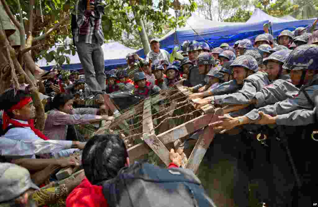 Student protesters struggle with riot police to remove a barricade installed by police during a protest in Letpadan, Myanmar, March 10, 2015.