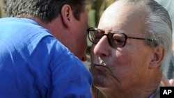 FILE - David Cameron, embraces his father, Ian, before addressing supporters in the garden of a public house in Swindon, south west England, Sunday April 18, 2010.