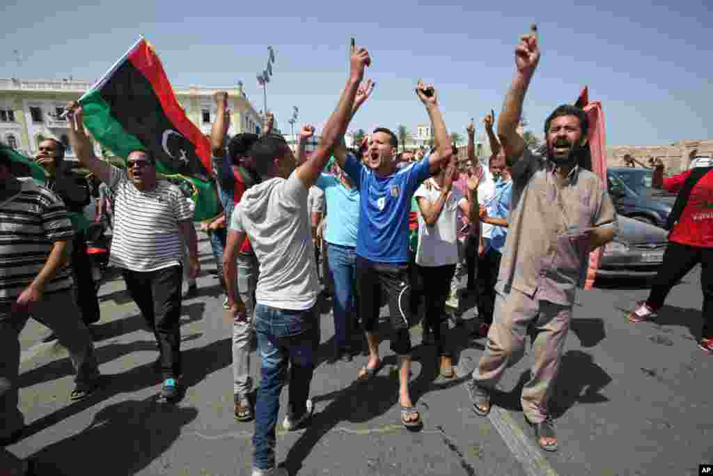 Libyans hold up their ink-marked fingers that shows they have voted as they celebrate in Martyrs' Square in Tripoli, Libya, Saturday, July 7, 2012. 