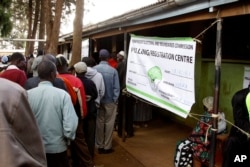 FILE - Kenyan voters line up to cast their votes in the Kibera slum, Nairobi, March 4, 2013.
