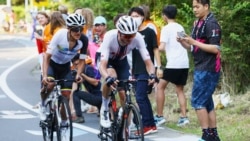 Fans watch Richard Carapaz of Ecuador and Brandon McNulty of the United States in the men's cycling road race at the 2020 Summer Olympics, Saturday, July 24, 2021, in Oyama, Japan. (Tim de Waele/Pool Photo via AP)