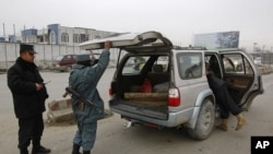 Afghan policemen search car at a checkpoint in Kabul, February 26, 2012 (file photo).