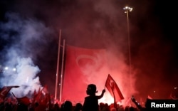 A young boy waves a Turkish national flag as supporters of Turkish President Tayyip Erdogan gather during a pro-government demonstration on Taksim square in Istanbul, Turkey, July 18, 2016.