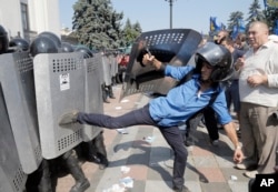 Ukrainian protesters clash with police after a vote to give greater powers to the east, outside the Parliament, Kyiv, Ukraine, Aug. 31, 2015.