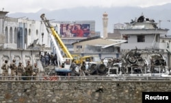 Afghan security forces inspect the site of suicide car bomb attack on a government security building in Kabul, Afghanistan, April 19, 2016.