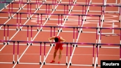 China's Liu Xiang leans against the last hurdle after crashing out of the heats in the 110 meter hurdles at the 2012 London Olympics. REUTERS/David Gray 