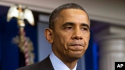 President Barack Obama pauses as he speaks about the death of Nelson Mandela in the briefing room of the White House, Dec. 5, 2013.