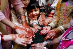 Muslims girls display their hands painted with traditional henna to celebrate Eid al-Fitr holidays, marking on the end of the fasting month of Ramadan, in Peshawar, Pakistan.