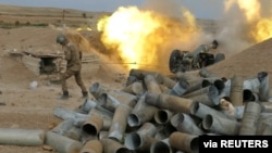 An ethnic Armenian soldier fires an artillery piece during a military conflict over the breakaway region of Nagorno-Karabakh, in this handout picture released Oct. 5, 2020.