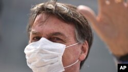 Brazil's President Jair Bolsonaro greets supporters during a protest against the Supreme Court and Brazil's National Congress, and to back Bolsonaro's open-the-economy drive, in Brasilia, Brazil, May 17, 2020. 