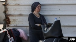 A Palestinian woman with a foreign passport waits at the Rafah gate hoping to cross into Egypt as Israel's attacks on the Gaza Strip continued on Oct. 14, 2023.