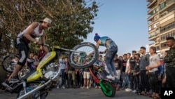 Men ride their motorcycles as they celebrate their friends' wedding before a curfew imposed as a prevention measure against the coronavirus pandemic, Cairo, April 16, 2020.