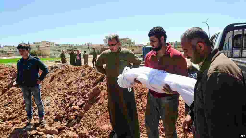 Syrians bury the bodies of victims of a a suspected toxic gas attack in Khan Sheikhun, April 5, 2017.