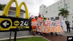 People protest for increased minimum wages outside a McDonald's restaurant in the Little Havana area in Miami, Florida.