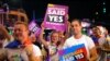 FILE - Participants hold banners regarding same-sex marriage during the 40th anniversary of the Sydney Gay and Lesbian Mardi Gras Parade in central Sydney, Australia, March 3, 2018.