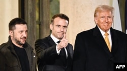 French President Emmanuel Macron gives a thumbs up as he is flanked by Ukrainian President Volodymyr Zelenskyy and U.S. President-elect Donald Trump after a meeting at the Elysee Presidential Palace in Paris on Dec. 7, 2024.