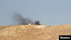 Smoke rises from a Lebanese army base as Lebanese Army soldiers clash with Islamist militants on the mountains next to the entrance of Arsal, August 3, 2014.