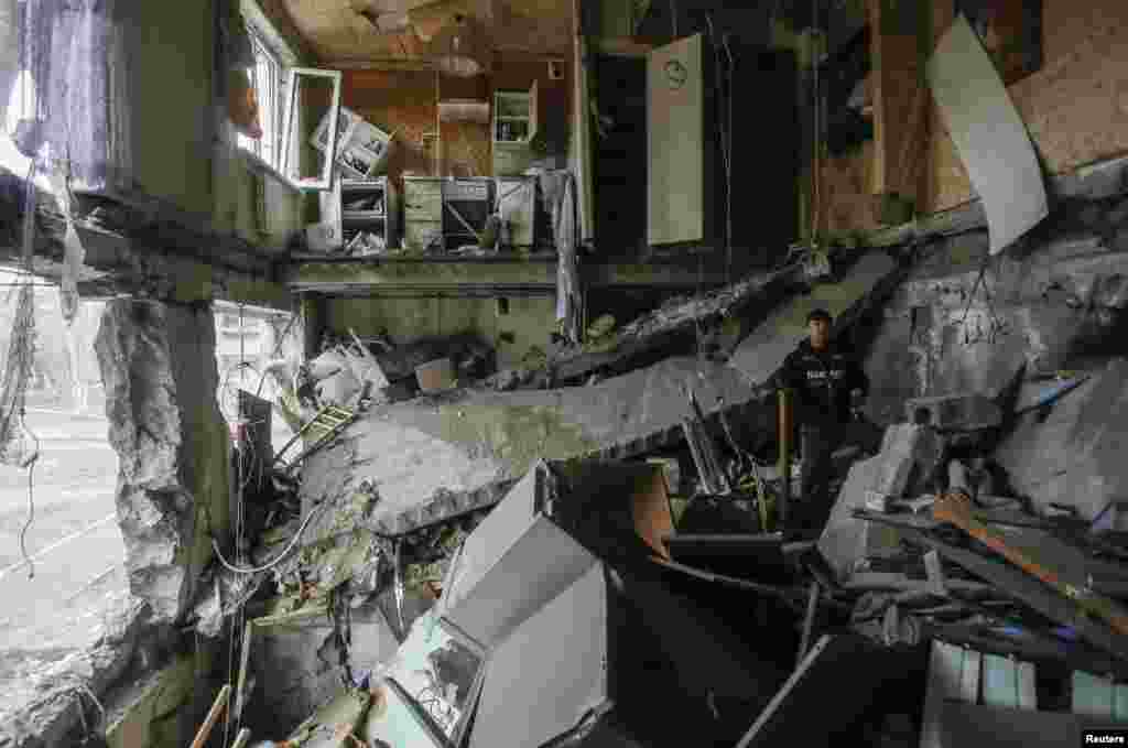 A man stands in a flat damaged by recent shelling in Yenakieve, a town northeast of Donetsk, Feb. 2, 2015.