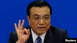 China's Premier Li Keqiang gestures as he speaks during a news conference, after the closing ceremony of the Chinese National People's Congress (NPC) at the Great Hall of the People, in Beijing, March 13, 2014.