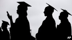 FILE - New graduates line up before the start of the Bergen Community College commencement at MetLife Stadium in East Rutherford, New Jersey, May 17, 2018.