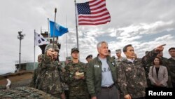 Bộ trưởng Quốc phòng Nam Triều Tiên Kim Kwan-jin hướng dẫn Bộ trưởng Quốc phòng Hoa Kỳ Chuck Hagel trong chuyến thị sát khu vực phi quân sự giữa 2 miền Nam, Bắc Triều Tiên