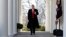 FILE - President Donald Trump waves as he walks through the Colonnade from the Oval Office of the White House, Jan. 25, 2019.
