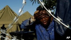 FILE - A man washes his face outside a shelter for displaced foreigners in east of Johannesburg, South Africa, April 21, 2015. 