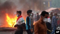 Anti-government protesters set fires and close streets during ongoing protests in Baghdad, Iraq, Nov. 9, 2019. 