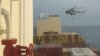 In this photo taken from video, an Iranian commando rappels from a helicopter in a raid on the MSC Aries in the Strait of Hormuz on April 13, 2024.