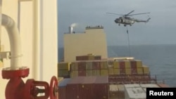In this photo taken from video, an Iranian commando rappels from a helicopter in a raid on the MSC Aries in the Strait of Hormuz on April 13, 2024.