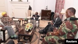 President Robert Mugabe, center, in a meeting with the ZDF Commander General Constantino Chiwenga, South African Minister of Defense Nosiviwe Mapisa-Nqakula (in yellow head wear), Zimbabwe Defense Minister Dr Sydney Sekeramayi and Zimbabwe State Security Minister Cde Kembo Mohadi at State House in Harare, Zimbabwe, Nov. 16, 2017. 