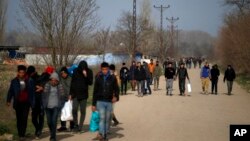 FILE - Migrants walk in Edirne at the Turkish-Greek border, March 9, 2020.