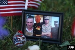 A photograph of the victims is seen among the memorial setup in front of the Armed Forces Career Center/National Guard Recruitment Office in Chattanooga, Tennessee, July 18, 2015.