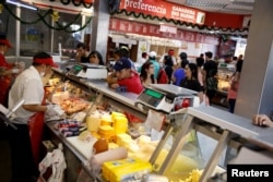 Carlos Rivero, who travelled by bus from Venezuela to Chile, looks at the display of products in the counter of a shop in Santiago, Chile, Nov. 18, 2017.