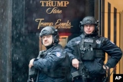Heavily armed police officers stand guard in the rain outside Trump Tower, Nov. 29, 2016, in New York.