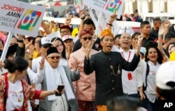 FILE - Indonesian President Joko Widodo, center right, walks and his running mate Ma'ruf Amin during a ceremony marking the kick off of the campaign period for next year's election in Jakarta, Sept. 23, 2018.
