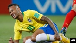 Le Brésilien Neymar se tient le tibia lors du match de quart de finale entre le Brésil et la Belgique lors de la Coupe du monde 2018 de football à Kazan Arena, Russie, 6 juillet 2018. 