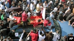 A funeral procession for Ali Abdulhadi Mushaima, 21, who was killed in clashes Monday in nationwide anti-government protests, moves slowly through the streets of Jidhafs, Bahrain, February 15, 2011
