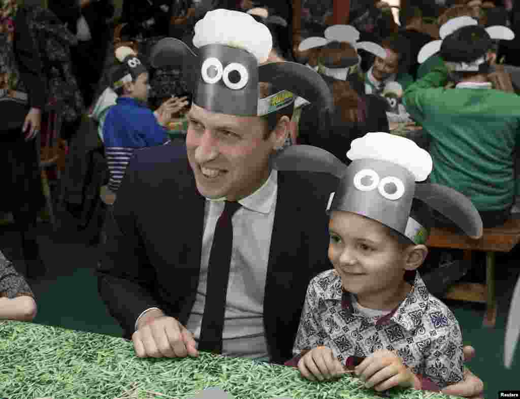 Britain's Prince William poses for photographs with a Shaun the Sheep hat, with children and representatives from charities and Aardman Animations, during a meeting of the Charities Forum at the British Academy of Film and Television Arts (BAFTA) in London.