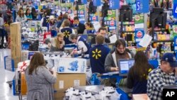 FILE - Shoppers are seen checking out at a Walmart store in Bentonville, Arkansas. Retail sales dipped 0.1 percent last month as automobile purchases fell and cheaper gasoline undercut receipts at service stations. 