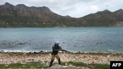 Des membres des services de police métropolitains affrontent des manifestants de la communauté du Hangberg lors de manifestations sur les droits de pêche, le 14 septembre 2017, dans la destination touristique et de pêche de Hout Bay, près du Cap, en Afriq