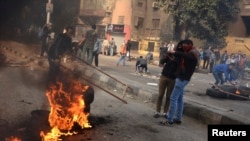 FILE - Supporters of the Muslim Brotherhood and ousted Egyptian President Mohamed Morsi close the road during clashes with riot police in Cairo, on the third anniversary of Egypt's uprising, Jan. 25, 2014.