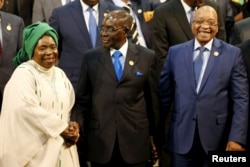 Chairperson of the African Union (AU) Commission Nkosazana Dlamini-Zuma (L) smiles as she is greeted by Zimbabwe's President Robert Mugabe next to South Africa's president Jacob Zuma ahead of the 25th African Union summit in Johannesburg, June 14, 2015.