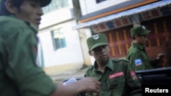 Armed soldiers from Burma's United Wa State Army shown riding a vehicle in neighboring China's border town of Mangka, September 3, 2009. 
