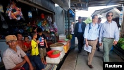 FILE - U.S. Secretary of State John Kerry (R) visits the village of Kien Vang along the Mekong River Delta, Vietnam, Dec. 15, 2013.