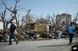 Warga berjalan melalui jalan-jalan dan rumah-rumah yang hancur setelah dihantam oleh Badai Irma, di Phillipsburg, St. Martin, 11 September 2017.