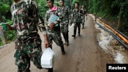 Rescue workers carry aid provisions near the Tham Luang cave complex in the northern province of Chiang Rai, Thailand, July 4, 2018. 