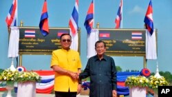 In this photo released by the Government Spokesman's Office, Thailand's Prime Minister Prayuth Chan-ocha (L) shakes hand with Cambodian's Prime Minister Hun Sen at the Thai-Cambodian border town of Aranyaprathet, Thailand, April 22, 2019.