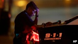 A Dallas police officer, who did not want to be identified, takes a moment as she guards an intersection in the early morning after a shooting in downtown Dallas on July 8, 2016.