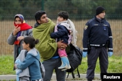 FILE - A migrant family approaches a registration center at a Croatia-Slovenia border crossing in Lendava, Slovenia, Oct. 17, 2015.